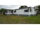 Charming white mobile home featuring gray trim, awnings, and a screened-in porch for outdoor enjoyment at 2618 Brookside Cir, Mount Dora, FL 32757