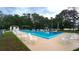 Community pool with white patio furniture surrounded by lush landscaping at 2618 Brookside Cir, Mount Dora, FL 32757