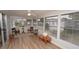 Bright sunroom featuring wood-look floors, neutral walls, and a ceiling fan for comfortable relaxation and natural light at 2618 Brookside Cir, Mount Dora, FL 32757