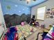 Bright bedroom featuring colorful wall art, play area, and a toy nook at 2691 Cypress Tree Trl, St Cloud, FL 34772