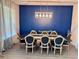 Formal dining room boasts a decorative accent wall and a modern chandelier over a table with seating for eight at 2691 Cypress Tree Trl, St Cloud, FL 34772