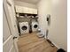 Functional laundry room with washer, dryer, storage shelves and modern cleaning appliances at 2691 Cypress Tree Trl, St Cloud, FL 34772