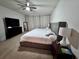 Cozy main bedroom with a king-size bed, a ceiling fan, and neutral curtains for privacy at 2691 Cypress Tree Trl, St Cloud, FL 34772