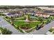 Scenic aerial view of the neighborhood featuring well-maintained homes and a central community park with a playground at 2702 Giardino Loop, Kissimmee, FL 34741
