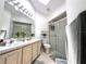 Bright bathroom featuring a double sink vanity, shower with glass doors, and a neutral color scheme at 2711 Emerson Ln, Kissimmee, FL 34743