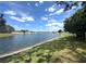 View of a large pond surrounded by green grass, neighborhood in background at 2711 Emerson Ln, Kissimmee, FL 34743