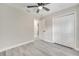A bedroom with neutral paint, hardwood floors, ceiling fan, closet, and a doorway to an adjacent room at 308 E Orange St, Kissimmee, FL 34744