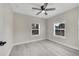 A bedroom offers neutral paint, hardwood floors, a ceiling fan, and windows for natural light at 308 E Orange St, Kissimmee, FL 34744
