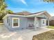 Charming single-story home with a covered front porch and a light blue exterior at 308 E Orange St, Kissimmee, FL 34744
