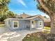 Charming blue home with a covered front porch, white trim, and a well-maintained yard at 308 E Orange St, Kissimmee, FL 34744