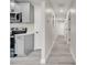 View of the hallway with doors leading to bedrooms and bathrooms and view to kitchen at 308 E Orange St, Kissimmee, FL 34744