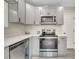 A modern kitchen features stainless steel appliances, grey cabinets, and sleek quartz countertops at 308 E Orange St, Kissimmee, FL 34744