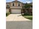 Two-story townhome with a two car garage, a driveway, and lush green landscaping at 3319 Rodrick Cir, Orlando, FL 32824