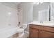 Bathroom featuring a vanity with dark wood cabinets and a tub/shower combo with white tile surround at 3589 Cortland Dr, Davenport, FL 33837