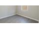 A well-lit room featuring grey flooring, white trim, and a window allowing natural light to fill the space at 3589 Cortland Dr, Davenport, FL 33837