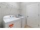 Laundry room with white appliances, wire shelving and a white door, creating an organized space at 3589 Cortland Dr, Davenport, FL 33837