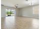 Bright living room with neutral tile floors and sliding glass doors to the backyard at 3589 Cortland Dr, Davenport, FL 33837