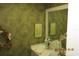Compact bathroom with patterned wallpaper, vanity and mirror, ideal for guests at 386 San Jose Dr, Winter Haven, FL 33884
