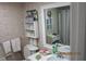 Cozy bathroom with wallpaper, mirror, white shelves, sink, and toilet at 386 San Jose Dr, Winter Haven, FL 33884