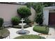 Picturesque courtyard with a tranquil fountain, bench, and manicured shrubbery at 386 San Jose Dr, Winter Haven, FL 33884