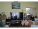 Inviting living room with large TV, ample storage boxes, and natural light from nearby window at 386 San Jose Dr, Winter Haven, FL 33884