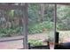 Looking from the screened porch to the foliage in the backyard at 386 San Jose Dr, Winter Haven, FL 33884