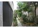 Side yard with partial screened-in patio, garden path, and lush surrounding greenery at 386 San Jose Dr, Winter Haven, FL 33884