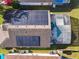 An aerial view showcasing a home with solar panels and a screened-in pool, blending sustainability and relaxation at 421 Bailey Cir, Davenport, FL 33897