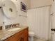 Well-lit bathroom featuring a granite countertop vanity, round mirror and shower-tub combination at 421 Bailey Cir, Davenport, FL 33897
