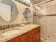 Bathroom showcasing a double sink vanity with granite countertop and a glass-enclosed shower with tile at 421 Bailey Cir, Davenport, FL 33897