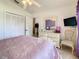 Cozy bedroom with ceiling fan, light pink quilt, white dresser and door to possibly ensuite bathroom at 421 Bailey Cir, Davenport, FL 33897