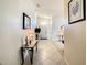 Welcoming hallway with tile flooring, decorated with plants and art leading to the front door at 421 Bailey Cir, Davenport, FL 33897