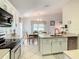 Open kitchen featuring stainless steel appliances, white cabinetry, and a breakfast nook dining area at 421 Bailey Cir, Davenport, FL 33897