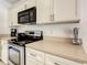 Contemporary kitchen featuring granite countertops, stainless steel appliances, and white cabinetry at 421 Bailey Cir, Davenport, FL 33897