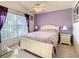 Relaxing main bedroom featuring large windows, purple accents, and comfortable furniture at 421 Bailey Cir, Davenport, FL 33897