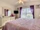 Bright main bedroom featuring a ceiling fan, a dresser and large window overlooking backyard at 421 Bailey Cir, Davenport, FL 33897