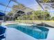 Bask in the privacy of this screened-in pool, a refreshing oasis surrounded by lush greenery at 421 Bailey Cir, Davenport, FL 33897