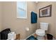 This bathroom features a toilet, window for natural light, and teal accent rug at 4301 Mohawk Ct, St Cloud, FL 34772