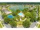 Aerial view of community amenities, including a large pool, tennis courts, a lake, and meticulously maintained landscaping at 4301 Mohawk Ct, St Cloud, FL 34772