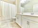 Bright bathroom with double vanity, tile floor, and shower with curtain at 4310 Seven Canyons Dr, Kissimmee, FL 34746