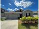 Inviting one-story home featuring a two-car garage, landscaped front yard, and cozy entrance at 4310 Seven Canyons Dr, Kissimmee, FL 34746