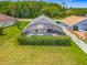 An aerial view shows a spacious backyard and screened-in pool surrounded by lush hedges for added privacy at 4413 Chalfont Dr, Orlando, FL 32837