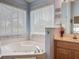 Bathroom featuring a garden tub with tile surround and a vanity with ample counter space at 4413 Chalfont Dr, Orlando, FL 32837