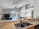 Open concept kitchen featuring stainless steel sink and view to living room and pool at 4413 Chalfont Dr, Orlando, FL 32837