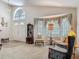 Open-concept living room featuring a soaring arched window and combination seating and dining areas at 4413 Chalfont Dr, Orlando, FL 32837