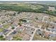 Aerial view of a residential community with a small pond, surrounded by trees and numerous homes at 491 Majestic Gardens Blvd, Winter Haven, FL 33880