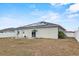 Back exterior view showcasing solar panels, access door, and privacy fence at 491 Majestic Gardens Blvd, Winter Haven, FL 33880