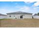 Back exterior view showcasing solar panels, access door, and sliding glass door at 491 Majestic Gardens Blvd, Winter Haven, FL 33880
