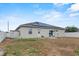 Exterior back view with an access door, solar panels, and a storage shed at 491 Majestic Gardens Blvd, Winter Haven, FL 33880
