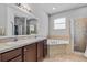 Bathroom features double sink vanity, soaking tub, and walk in shower at 491 Majestic Gardens Blvd, Winter Haven, FL 33880